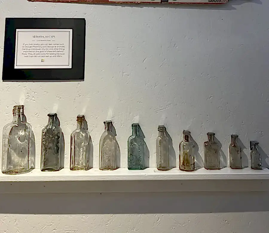 Row of antique medicine flasks from 1920s Vancouver pharmacies